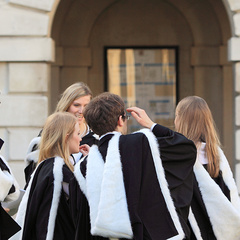 Groups of students in academical dress outside the Senate House following graduation