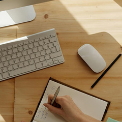 A person taking notes in a book while on a video call