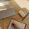 A person taking notes in a book while on a video call
