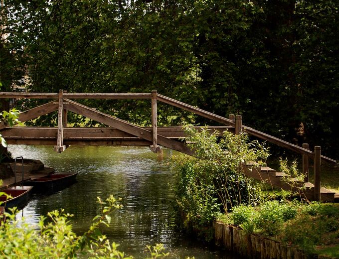 A wooden bridge spanning the River Cam in the grounds of Darwin College