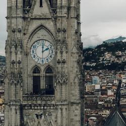 Two towers flanking a church both with clocks showing different times