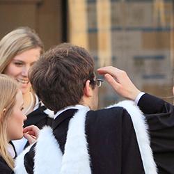 Groups of students in academical dress outside the Senate House following graduation