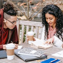 Three students studying together on a picnic bench