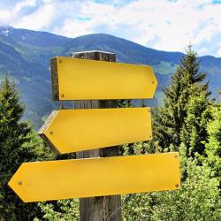 Yellow signpost in the mountains pointing in different directions