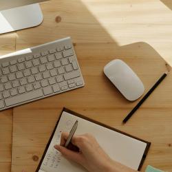 A person taking notes in a book while on a video call