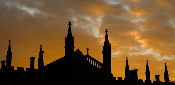 The sun setting behind and silhouetting buildings in Cambridge