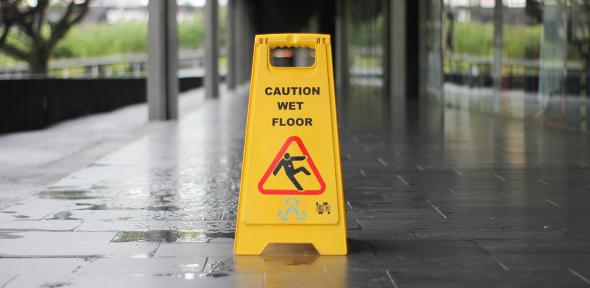 A wet floor caution cone on a train platform