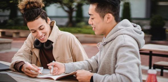 Two students exchanging feedback on work