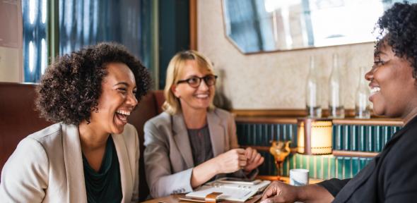 Three women having a discussion over coffee