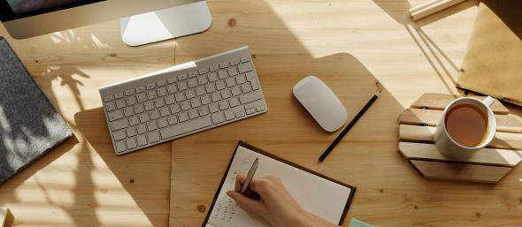 A person taking notes in a book while on a video call