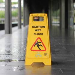 A wet floor caution cone on a train platform