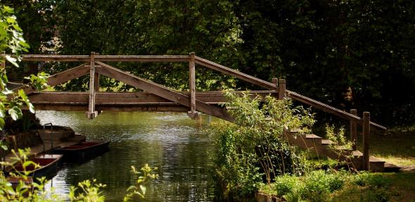 A wooden bridge spanning the River Cam in the grounds of Darwin College
