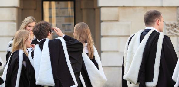 Groups of students in academical dress outside the Senate House following graduation