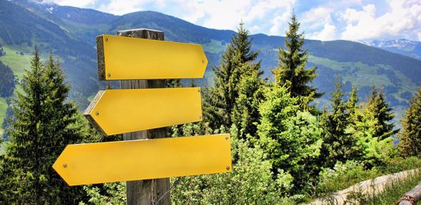 Yellow signpost in the mountains pointing in different directions